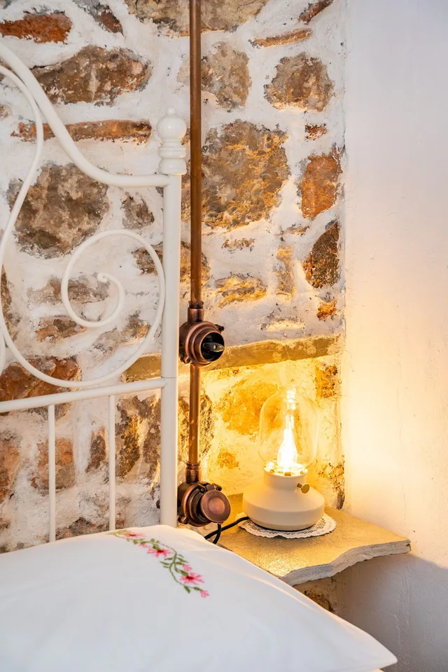 Stone wall and bedside detail in the Sea La Vue bedroom