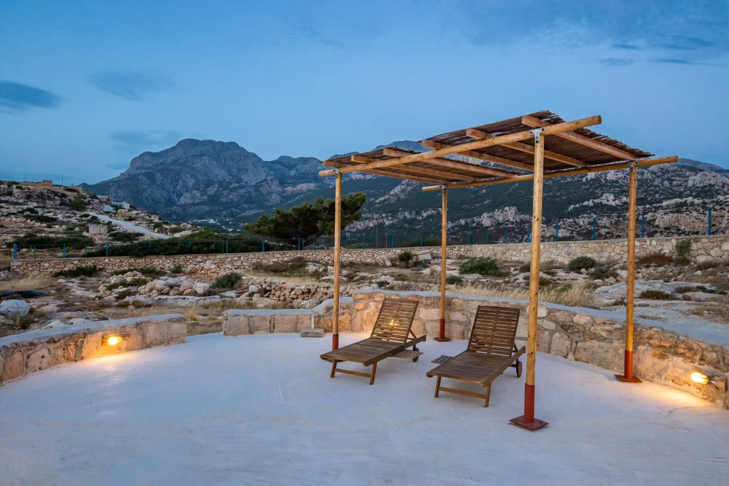 Το αλώνι του Sea La Vue με θέα στο βουνό το σούρουπο στον Λευκό Καρπάθου